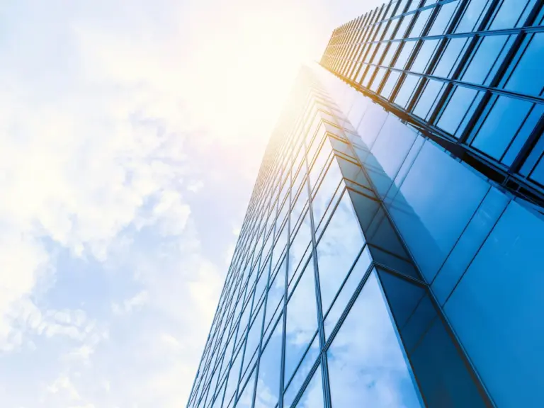 Glass office tower seen from below against the sky
